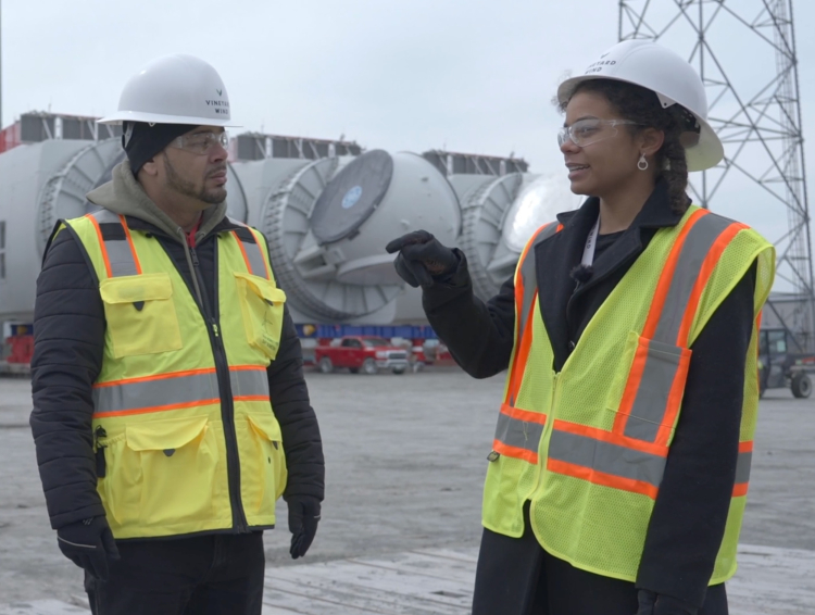 Two people in hardhats and safety vests at offshore wind terminal