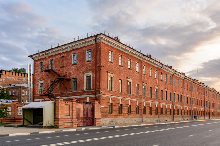 Old brick industrial building on the side of a road in an urban area.