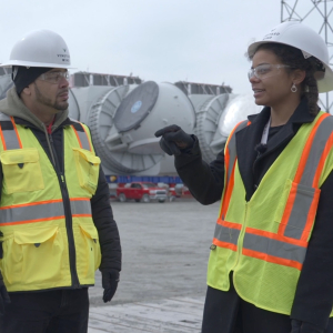 Two people in hardhats and safety vests at offshore wind terminal