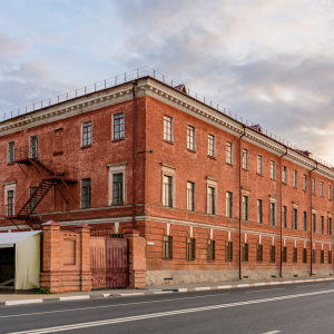 Old brick industrial building on the side of a road in an urban area.