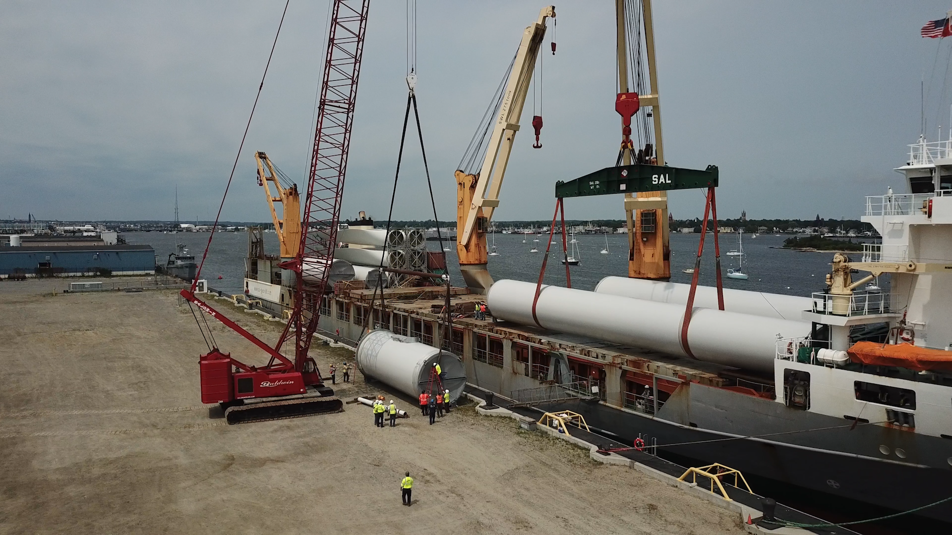Cranes unload wind turbine parts at New Bedford Marine Commerce Terminal dock
