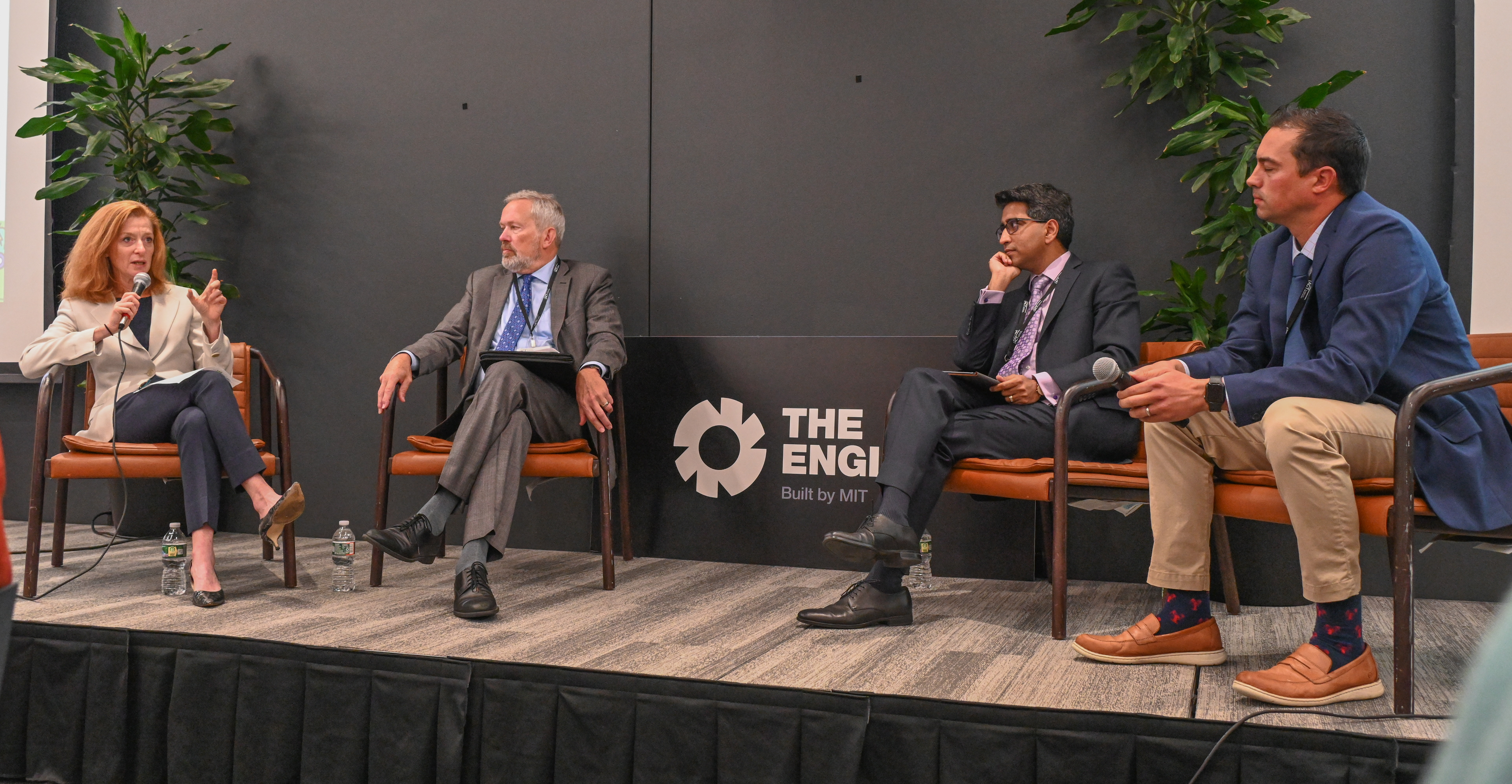 Four people seated on a stage, in discussion