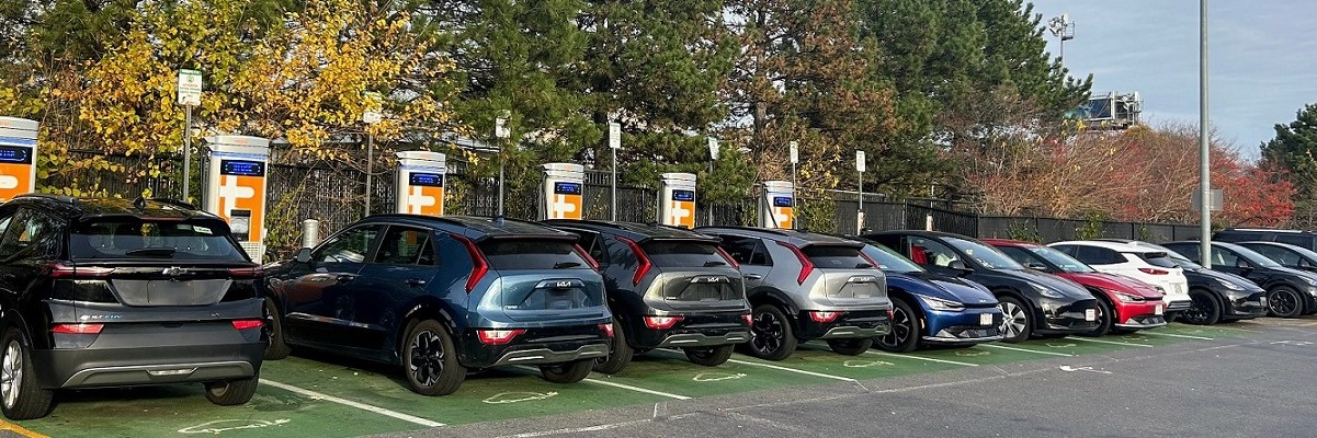 Line of cars at EV chargers in parking lot